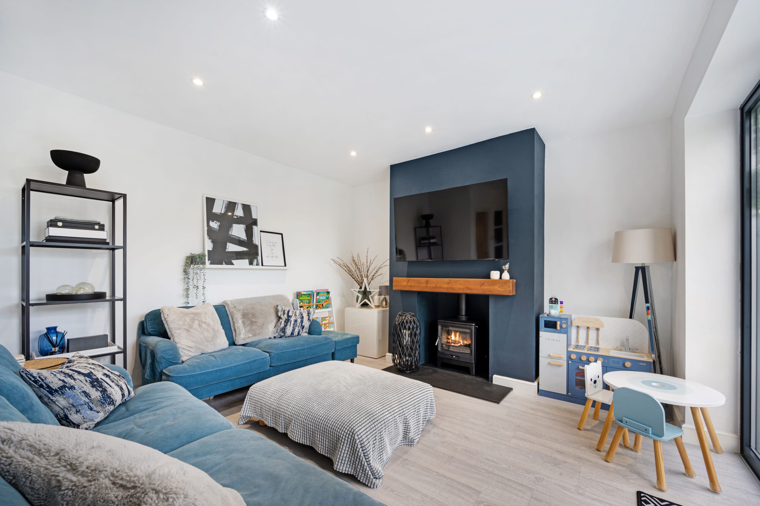 A family living room showing their blue sofa, fire place and soft furnishing in a retrofitted home