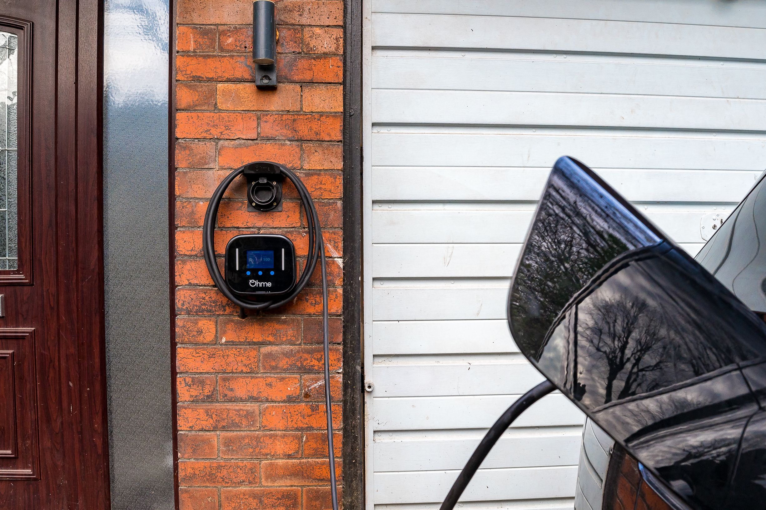 An Electric Vehicle Charger on the front of a retrofitted home