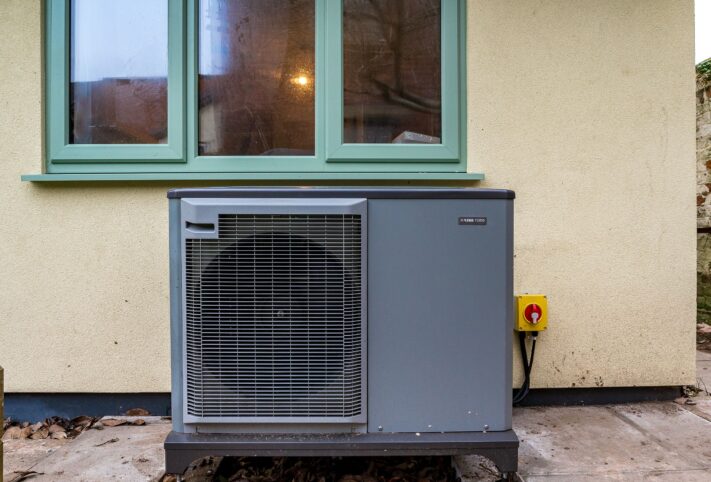 A Air Source Heat Pump outside of a retrofitted bungalow