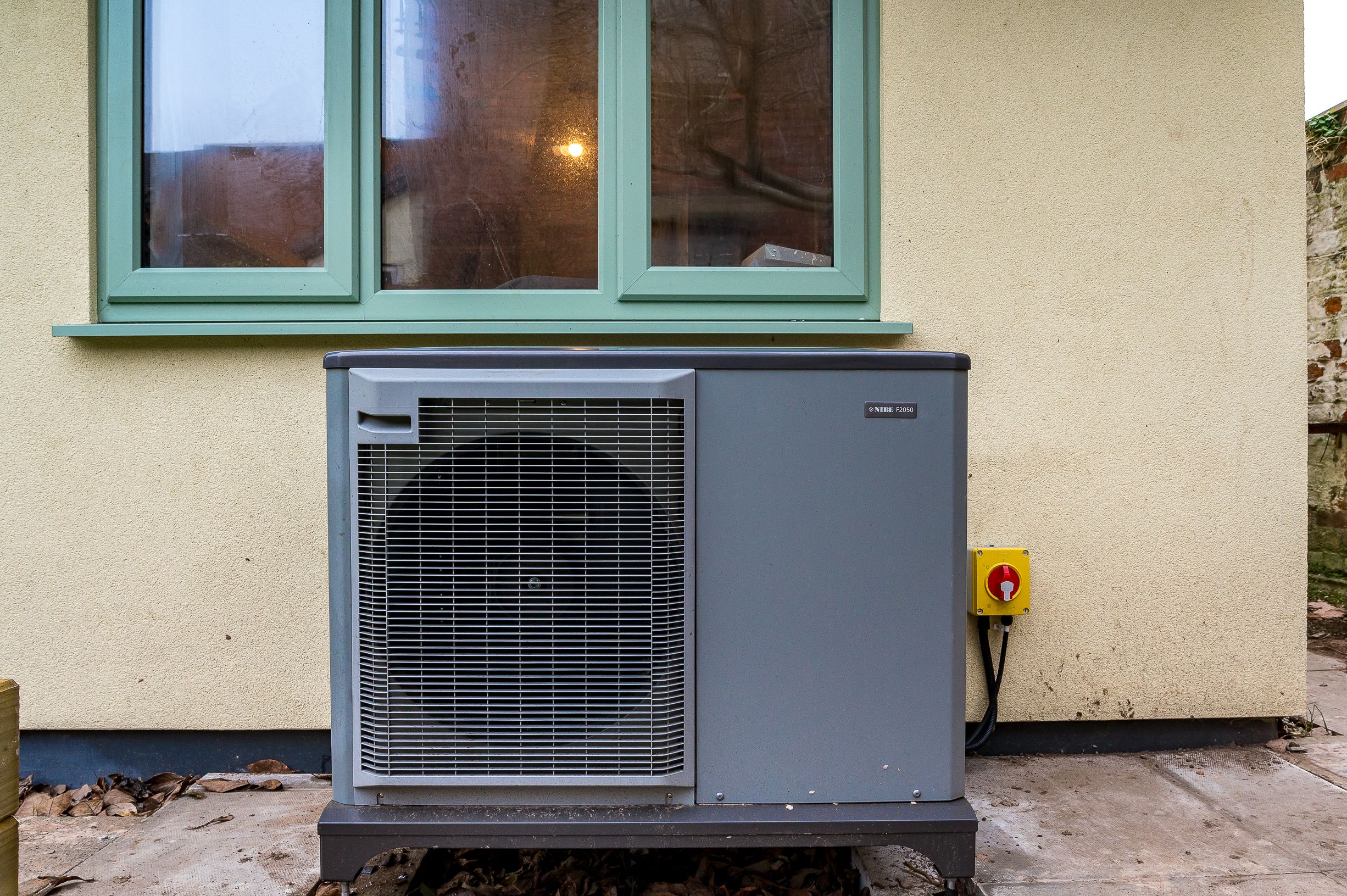 A Air Source Heat Pump outside of a retrofitted bungalow